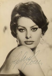 an old black and white photo of a woman with her hand on her shoulder, looking at the camera