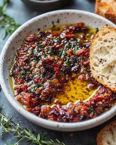 a white bowl filled with bread and cranberry sauce on top of a table