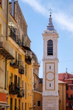 a tall white clock tower towering over a city