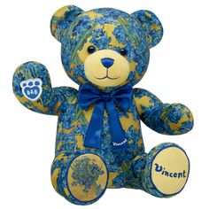 a blue and yellow teddy bear with flowers on it