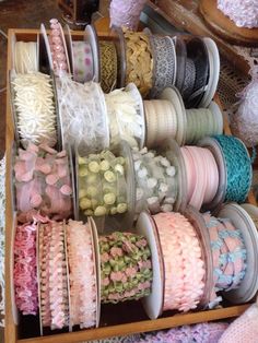 many different types of ribbons are on display in a box with ribbon spools