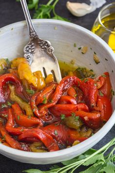 a white bowl filled with red peppers and herbs