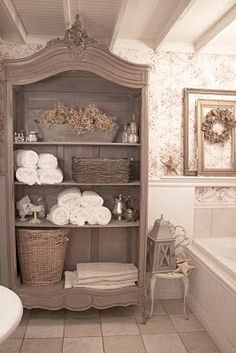 an old fashioned bathroom is decorated in white and beige colors, with antique decor on the shelves