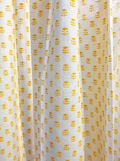 closeup of yellow and white curtains with trees on them