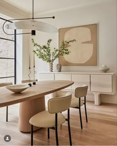 a dining room table with four chairs and a bowl on it's centerpiece