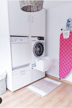 a washer and dryer in a room next to a wall with an ironing board