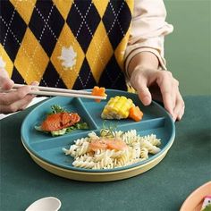 a person is holding chopsticks over a plate of food with noodles and vegetables on it