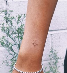 a woman's arm with a small tattoo on the left side of her wrist