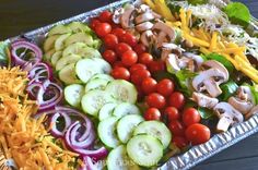 a metal tray filled with lots of different types of veggies on top of each other