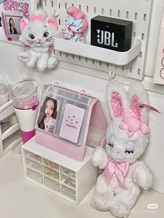 two stuffed animals sitting on top of a desk next to a cup and other items