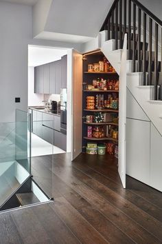 an open pantry under the stairs in a house