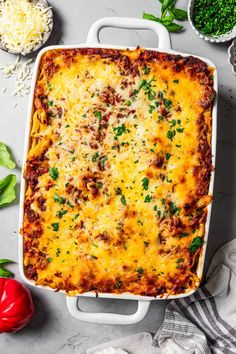 a casserole dish with meat and cheese in it, surrounded by other ingredients