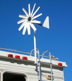 a large white windmill sitting on top of a metal structure next to a blue sky