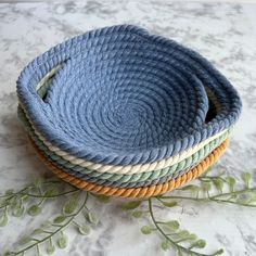 three baskets are stacked on top of each other, one is blue and the other is green