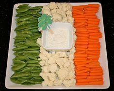 carrots, cauliflower, and celery are arranged on a platter