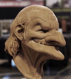 a clay sculpture of a man's face with his mouth open