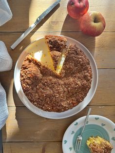 a plate with a piece of pie on it and an apple in the background,