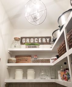 a pantry with white shelving and wooden shelves