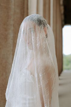 a woman wearing a white veil and wedding dress