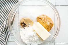 ingredients in a glass bowl for making peanut butter and jelly cookies on a tile surface