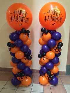 two tall balloons with happy halloween written on them