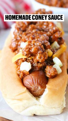 a chili dog on a bun with cheese and onions