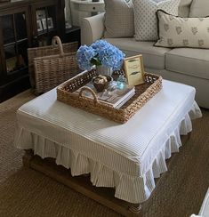 a living room filled with furniture and flowers on top of a coffee table in front of a couch