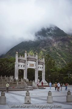 people are walking around in front of a mountain