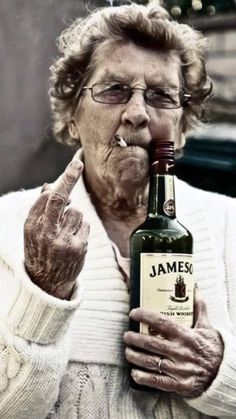 an old woman holding a bottle of jameson in her hand and making the middle finger sign