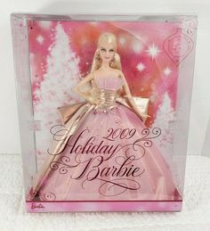 a barbie doll is displayed in a glass case with pink and gold trimmings