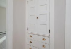 an empty white closet with gold handles and knobs on the doors is pictured in this image