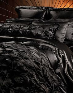 a black comforter and pillows on a bed