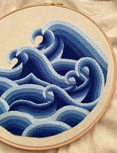 an embroidery project with blue waves on it