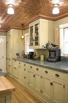 a kitchen with white cabinets and metallic ceiling