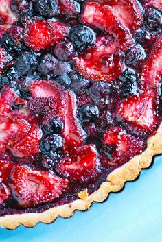 a pie with blueberries and strawberries on it