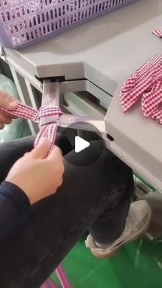 a person is tying a tie at a sewing machine