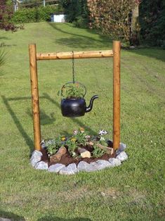 a potted plant is hanging from a wooden frame in the middle of a yard