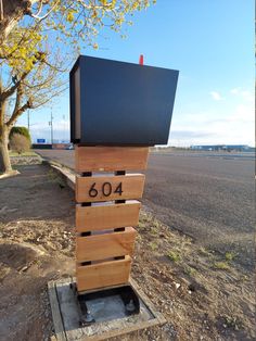 a mailbox sitting on top of a wooden box in the middle of a road