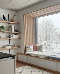 a window seat in the corner of a room with shelves on both sides and a bench at the far end