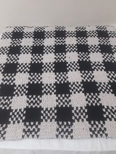 a black and white checkered blanket sitting on top of a bed