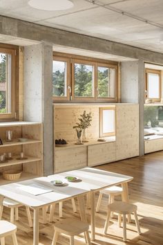 an empty room with tables, shelves and windows on the wall in front of them