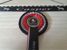 a black and red award ribbon with the number four on it's center piece