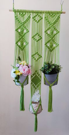 green macrame hanging planters with flowers in them