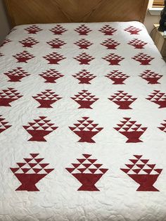 a bed with a red and white quilt on it