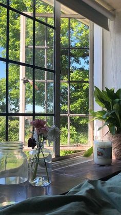 a vase filled with flowers sitting on top of a wooden table next to a window