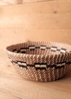 a woven basket sitting on top of a wooden table