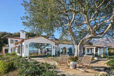 a large white house sitting next to a tree