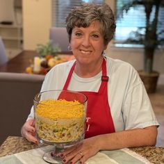 a woman sitting at a table with a bowl of food in front of her on the counter