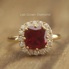 a close up of a ring with a red stone in the middle and white diamonds around it