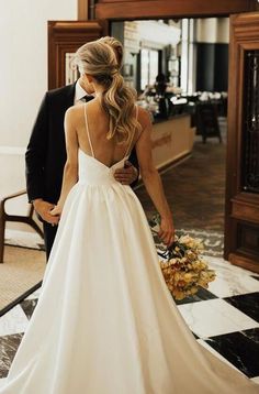 a woman in a white wedding dress standing next to a man wearing a tuxedo